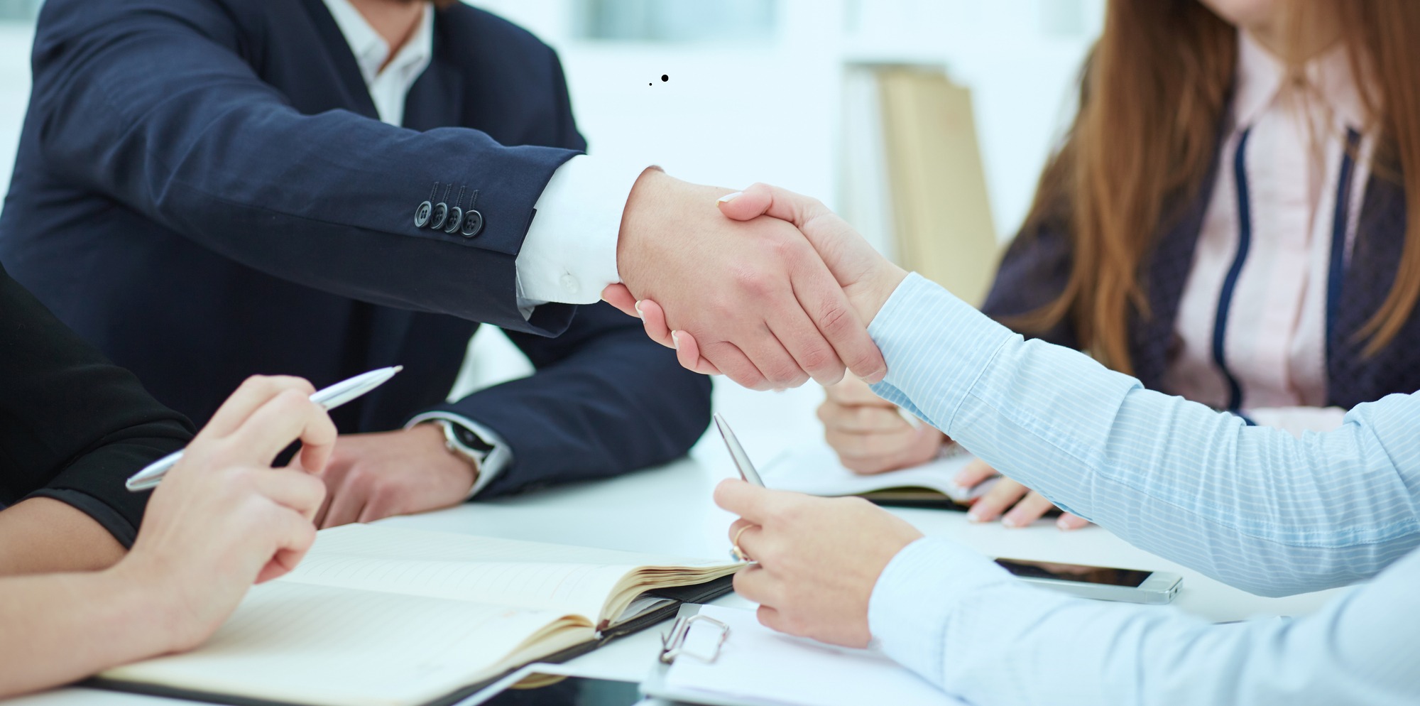 Male and female handshake in office. Serious business and partnership concept. Partners made deal, sealed with handclasp.